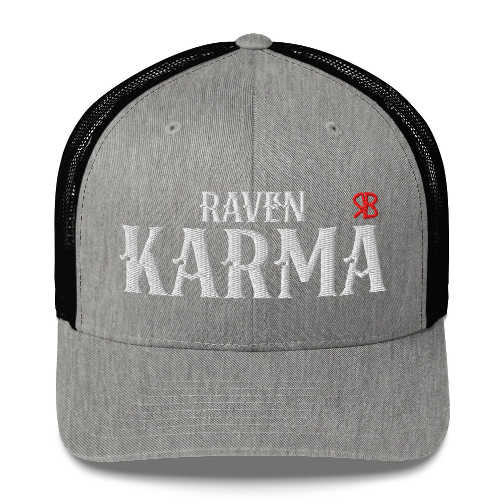 light grey / black retro trucker cap with mesh back. The front features bold white embroidered text reading "RAVEN KARMA" with a small red RB logo to the right.