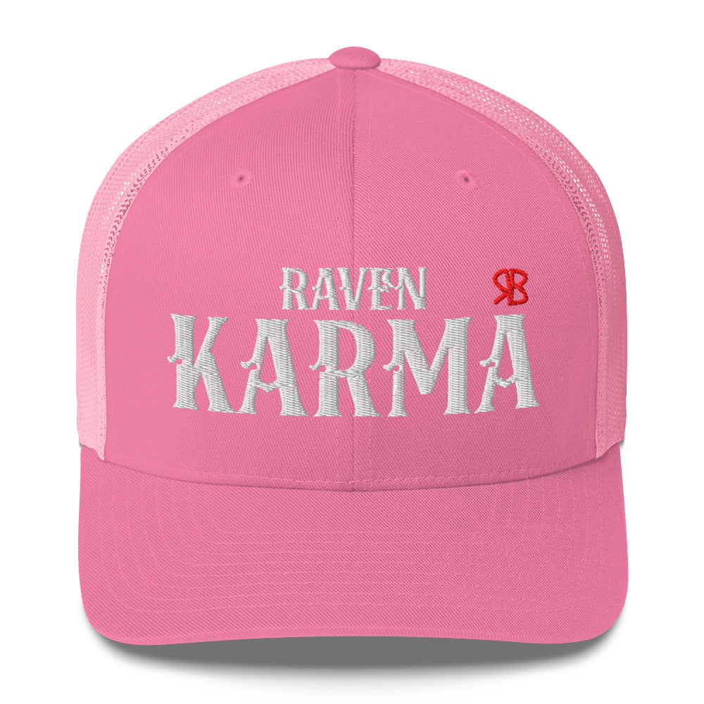 pink retro trucker cap with mesh back. The front features bold white embroidered text reading "RAVEN KARMA" with a small red RB logo to the right.