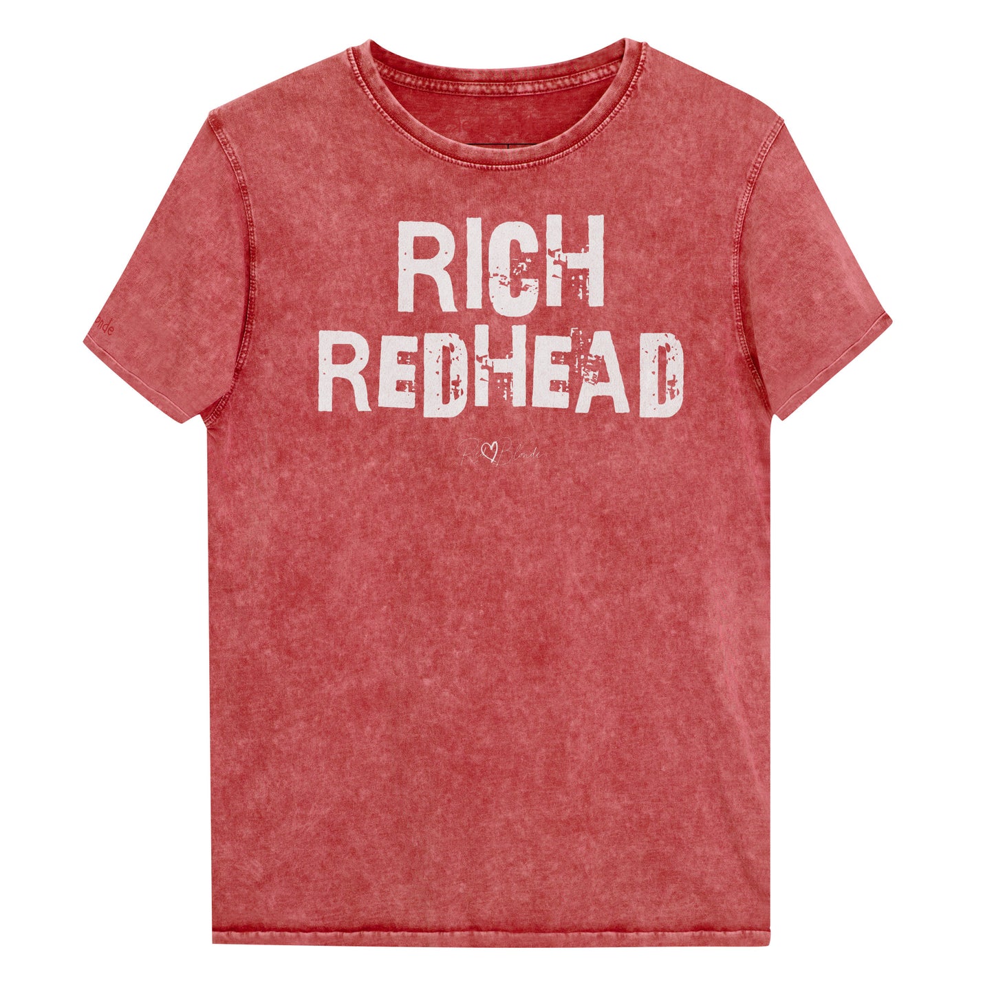 a red acid-wash unisex denim T-shirt with a distressed vintage look. The shirt features the bold white text “RICH REDHEAD” in a weathered Ed Gein font, and features the RedBlonde signature logo. The shirt has short sleeves, a crew neckline, and visible seam detailing for a rugged, casual style. Branded Redblonde on inside neck and right sleeve