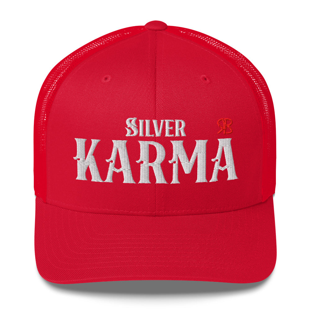red retro trucker cap with mesh back. The front features bold white embroidered text reading "SILVER KARMA" with a small red RB logo to the right.