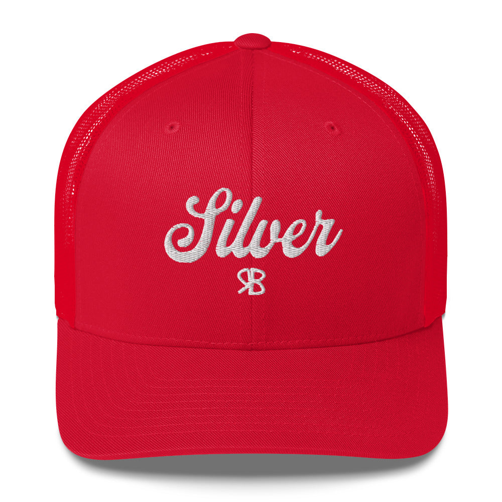 red trucker cap with 'Silver' in white adventurer 01 font on front. Mesh back. Branded RB