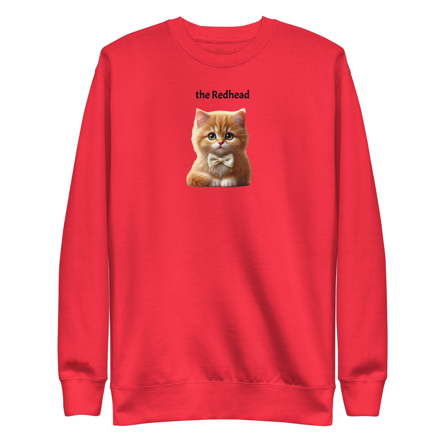 Flatlay of red relaxed fit unisex sweatshirt with a cute graphic of a redhead kitten wearing a bow-tie and the words 'the Redhead' linking to Red hair. Branded RedBlonde in red on inside neck and right cuff