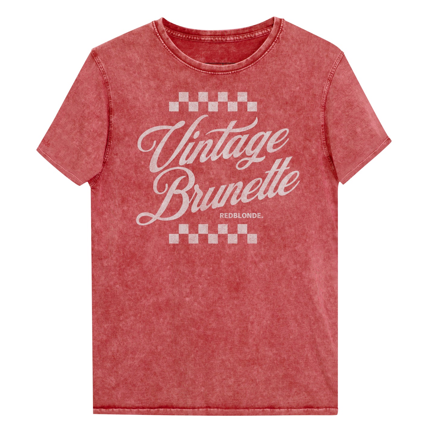 Red acid wash short-sleeve T-shirt featuring the bold white Milkstore 1 script text “Vintage Brunette” across the chest with checkerboard accents above and below the lettering. The brand name “RedBlonde.” is printed in small capital letters beneath the word “Brunette.” The shirt has a casual, slightly distressed look with visible stitching along the seams. Branded RedBlonde on inside collar and right sleeve
