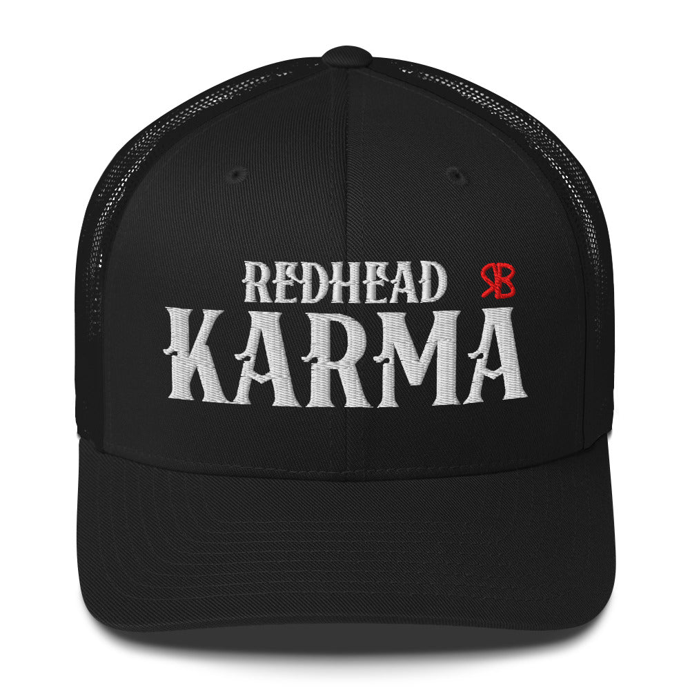black retro trucker cap with mesh back. The front features bold white embroidered text reading "REDHEAD KARMA" with a small red RB logo to the right.