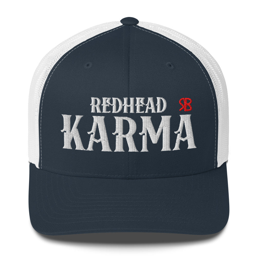 navy/white retro trucker cap with mesh back. The front features bold white embroidered text reading "REDHEAD KARMA" with a small red RB logo to the right.