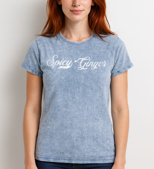 Redhead wears a blue unisex loose-fit denim wash t-shirt with vintage Coca-Cola-inspired milkstore script in white reading ‘Spicy Ginger’ on the front. Branded RedBlonde on the inside neck and right shoulder in red
