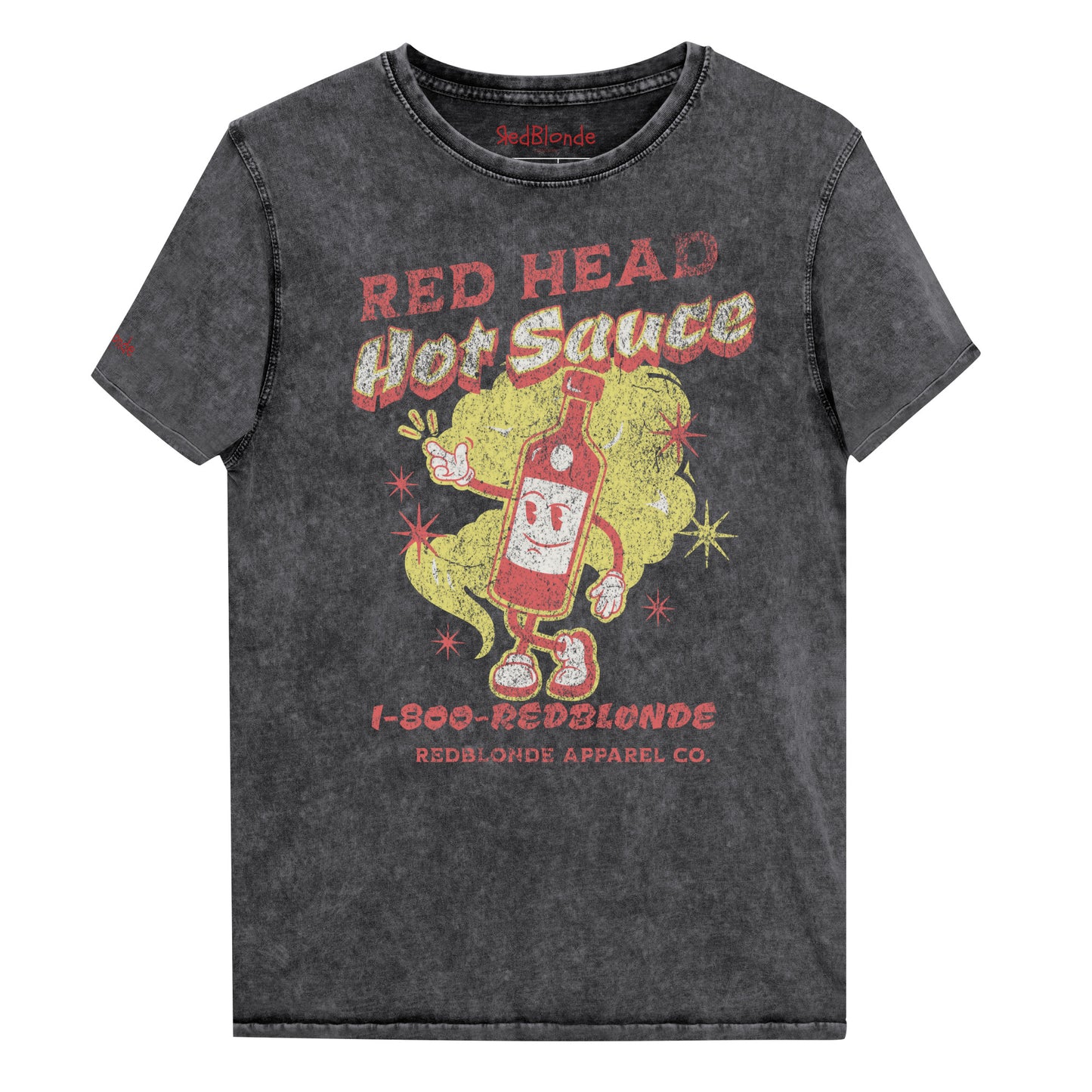 flatlay of a relaxed unisex black denim-wash t-shirt with a distressed retro American-vintage pop-art graphic featuring a bottle of sauce with Red Head Hot Sauce text. Branded redblonde on inside neck and right shoulder in red