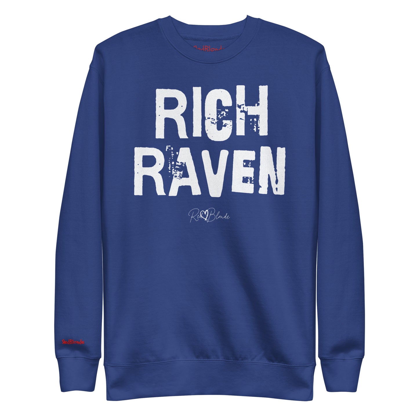 Royal Blue unisex premium sweatshirt with bold distressed white Ed Geinitext “RICH RAVEN” on the front, featuring a subtle RedBlonde logo beneath the lettering and on the sleeve cuff and inside neck