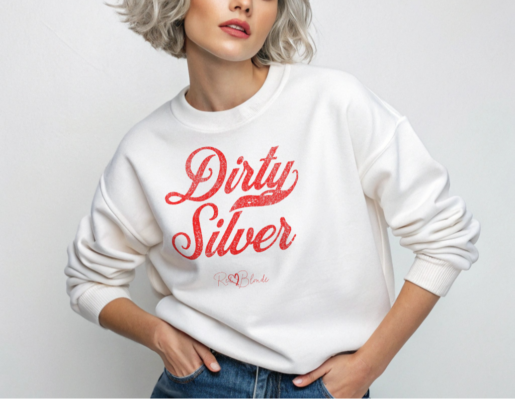 Silver haird model wears a white Classic relaxed fit premium unisex sweatshirt with the playful slogan ‘Dirty Silver’ in red milk-store font, signed off RedBlonde. Branded RedBlonde London in red on inside neck and right cuff