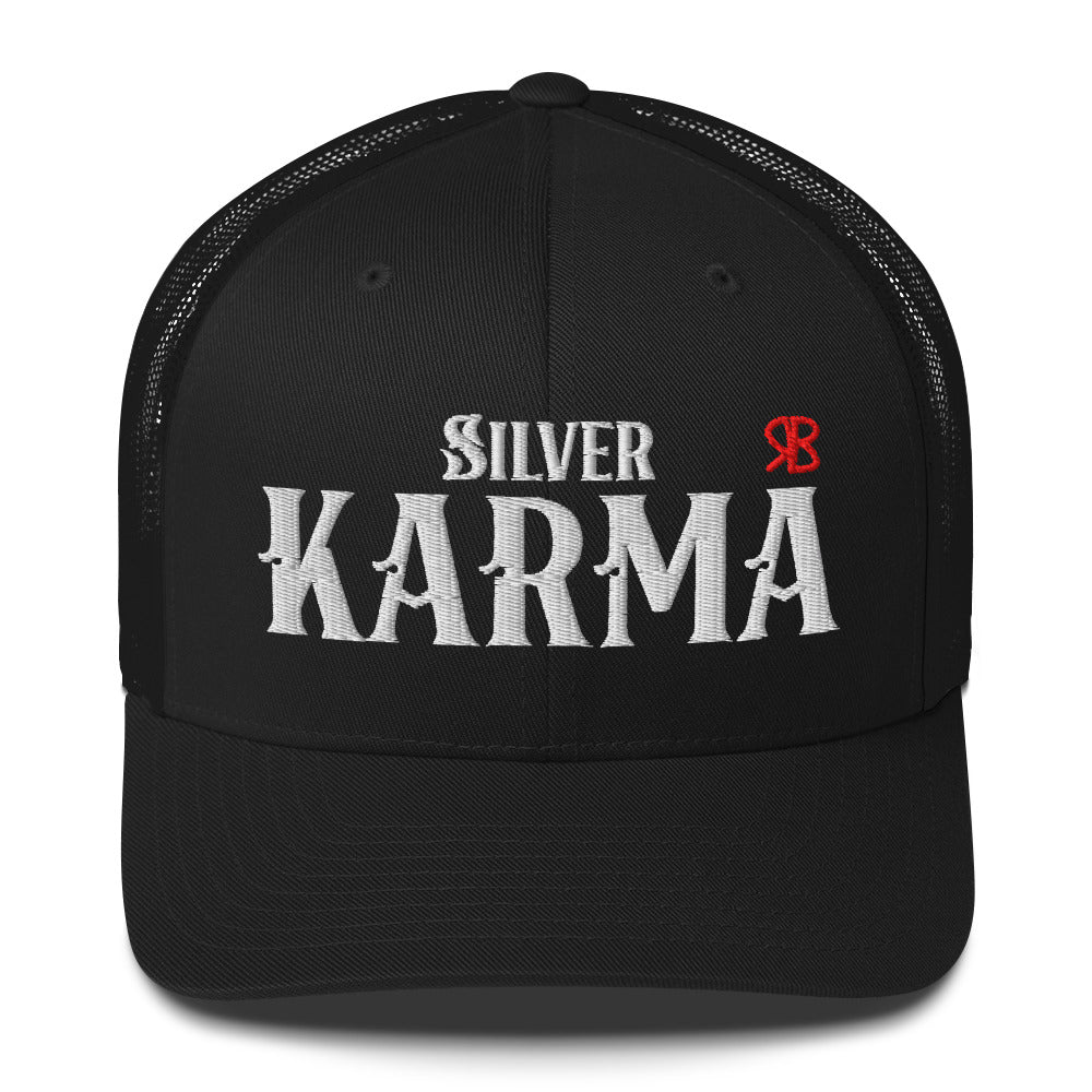 black retro trucker cap with mesh back. The front features bold white embroidered text reading "SILVER KARMA" with a small red RB logo to the right.