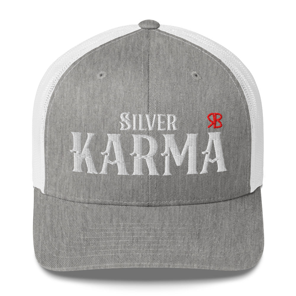light grey / white retro trucker cap with mesh back. The front features bold white embroidered text reading "SILVER KARMA" with a small red RB logo to the right.