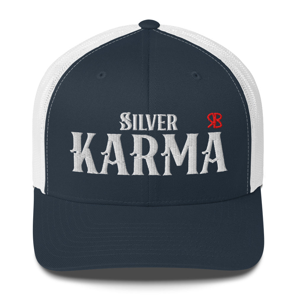 navy/white retro trucker cap with mesh back. The front features bold white embroidered text reading "SILVER KARMA" with a small red RB logo to the right.
