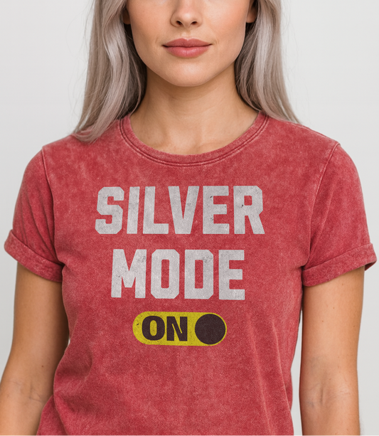 Silver model wears a red denim-style unisex t-shirt with bold distressed white Univercity font reading “Silver Mode” and a yellow on/off switch graphic in the “On” position beneath. The design includes subtle worn texture for a vintage look. Branded RedBlonde London in red on inside neck and right sleeve