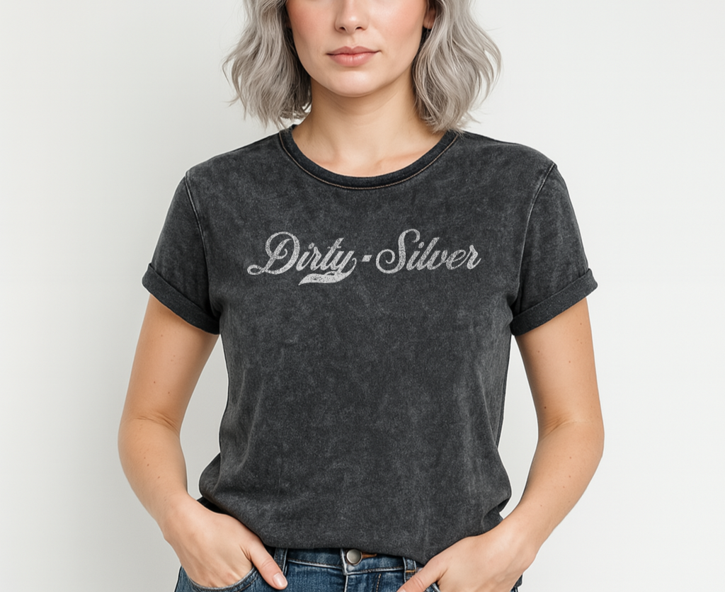 Flatlay of a black unisex loose-fit denim wash t-shirt with vintage Coca-Cola-inspired milkstore script in white reading ‘Dirty Silver’ on the front. Branded RedBlonde on the inside neck and right shoulder in red