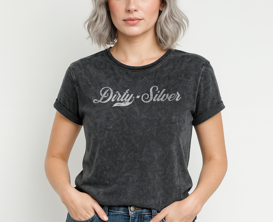 Flatlay of a black unisex loose-fit denim wash t-shirt with vintage Coca-Cola-inspired milkstore script in white reading ‘Dirty Silver’ on the front. Branded RedBlonde on the inside neck and right shoulder in red
