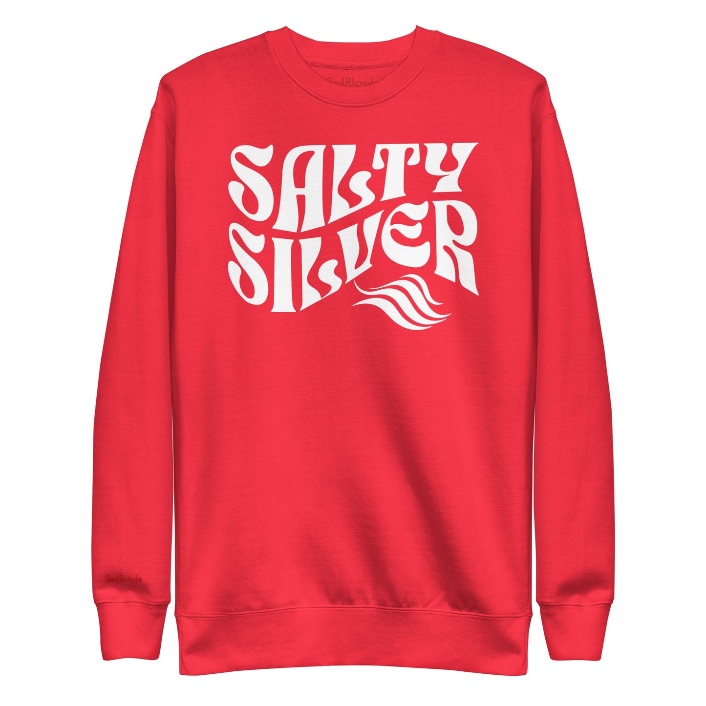 flatlay of Classic relaxed fit unisex sweatshirt in red with 'Salty Silver' play on words slogan in white retro 70s wavy text. Branded RedBlonde on inside neck and right cuff in red