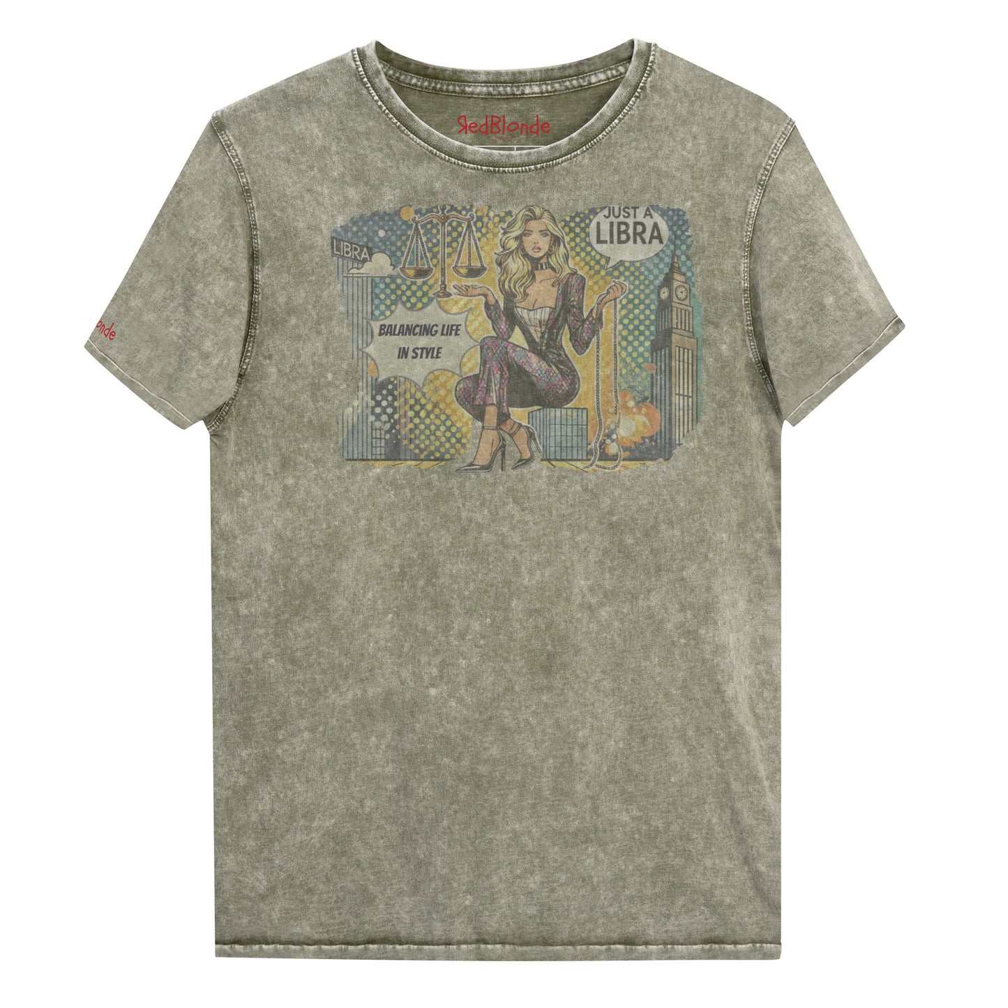 Flatlay of a unisex army green denim wash vintage t-shirt with a retro pop-art Libra graphic featuring a blonde woman, scales, and a city backdrop, captioned ‘Just a Libra, Balancing Life if Style’. Branded RedBlonde on inside neck and right sleeve