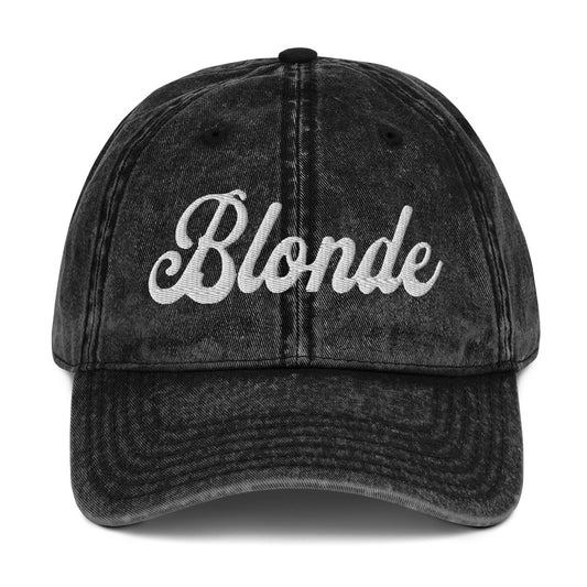 flatlay of vintage black denim wash effect baseball cap with the word 'Blonde' embroidered on the front in white adventure type script font