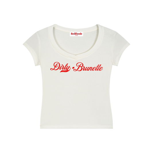 A fitted white V-neck T-shirt laid flat on a white background. It has short sleeves and a red Milkstore 01 script graphic across the chest reading “Dirty-Brunette.” A small RedBlonde label is visible at the inside back neck.