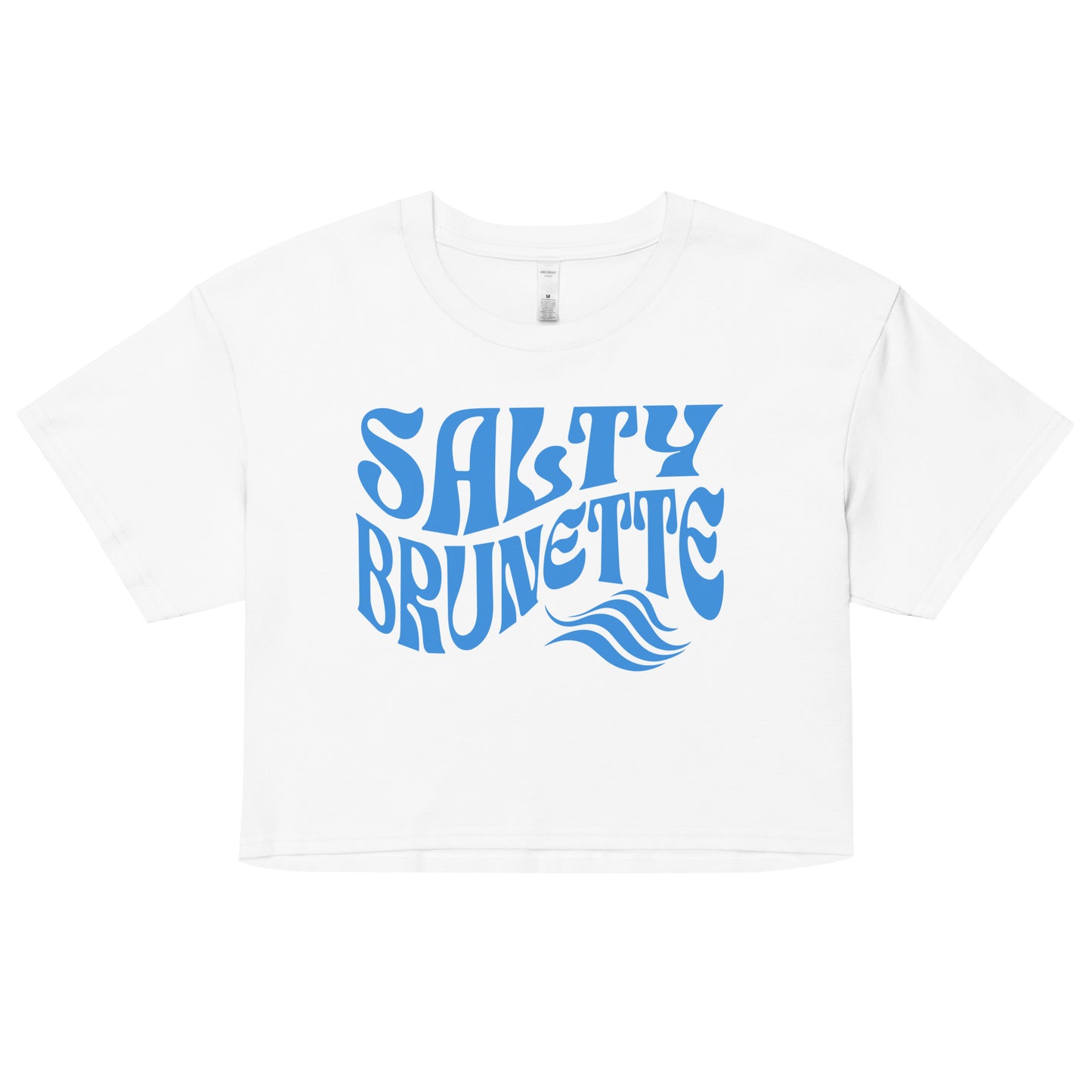 Flatlay of a white loose women's crop top t-shirt with the words ‘Salty Brunette’ in blue retro 70s font