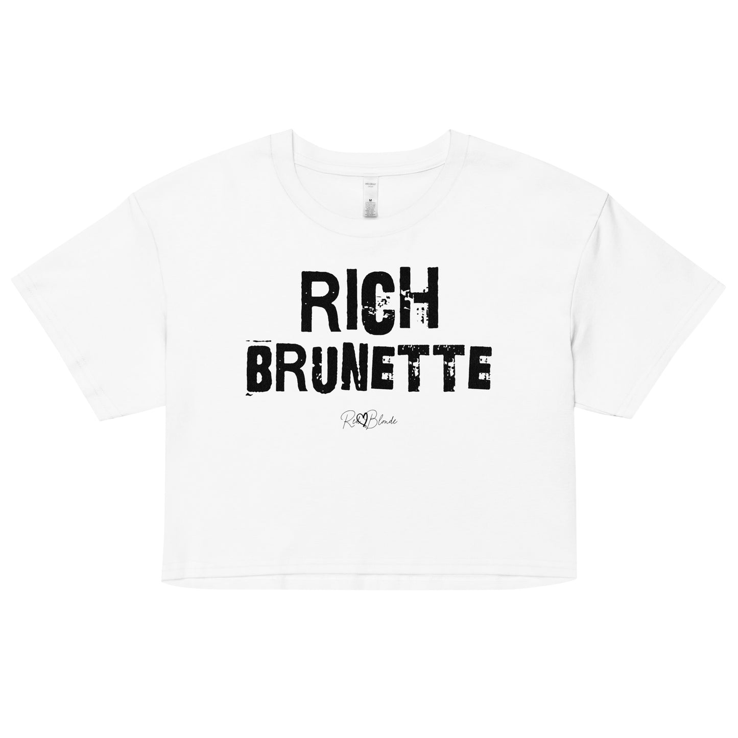 white crop top with a relaxed fit, short sleeves, and a wide crew neckline. The front features bold black distressed Ed Gein lettering reading “RICH BRUNETTE” with the RedBlonde signature logo underneath in black