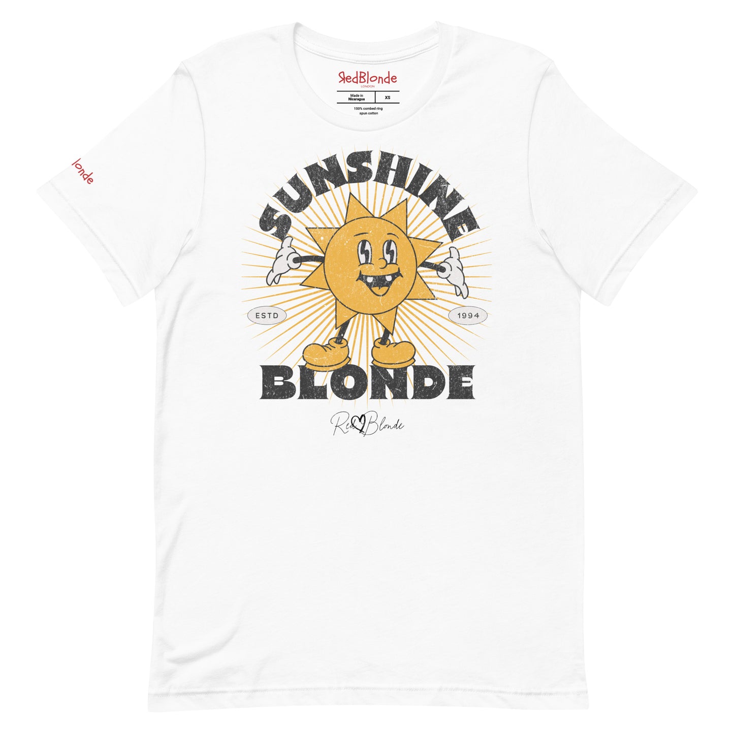 White unisex crew neck t-shirt with a retro cartoon-style yellow sun character, smiling with open arms, surrounded by radiant sunbeams. The text reads ‘Sunshine Blonde’ in bold vintage Belzebuth lettering, with small details including ‘ESTD 1994’ and the RedBlonde signature logo beneath."