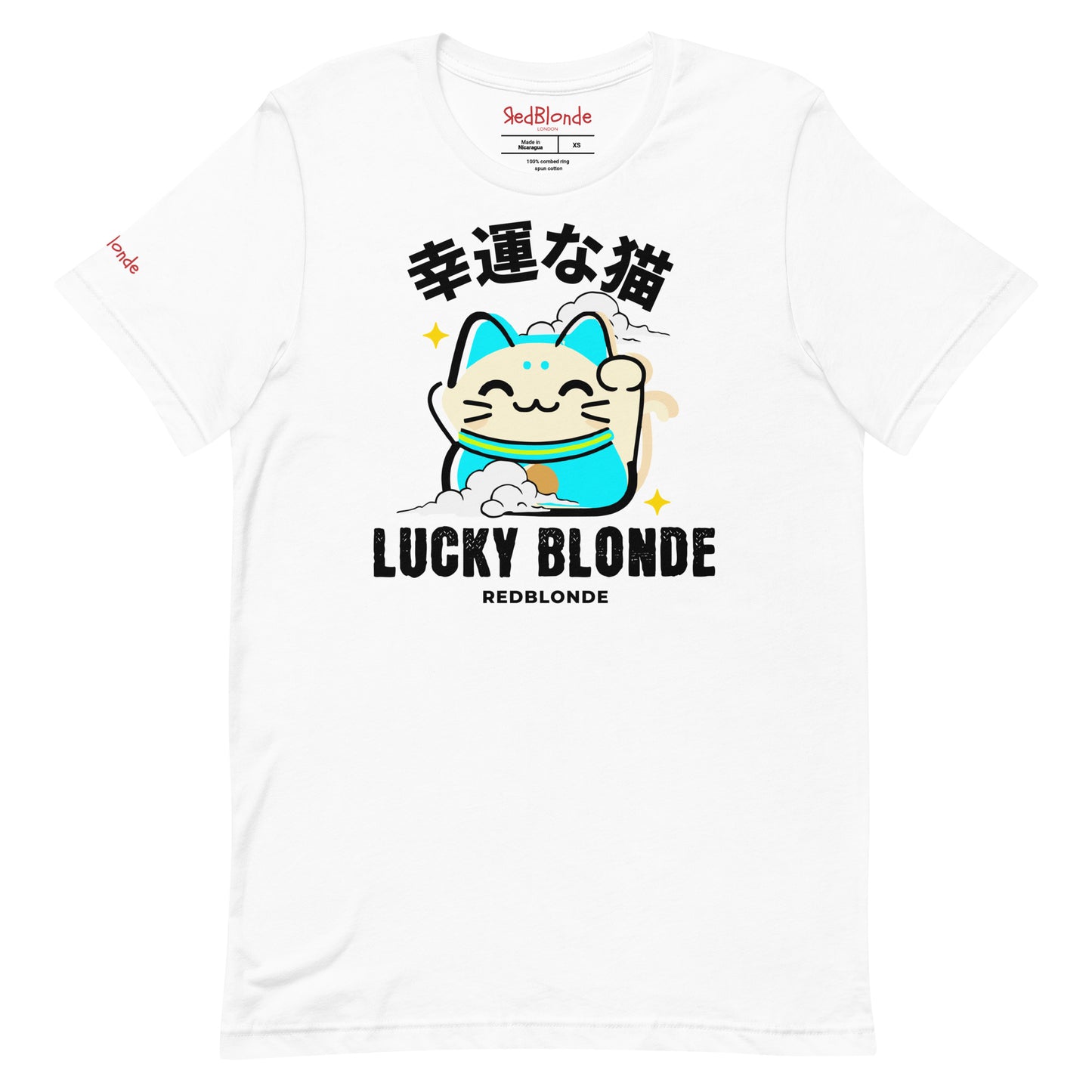 A white unisex T-shirt featuring a cheerful maneki-neko (lucky cat) graphic in cream, turquoise, and black, with golden star accents. Above the cat are Japanese characters meaning “Lucky Cat.” Below the design, the text reads “LUCKY BLONDE” in bold black letters and “REDBLONDE” in smaller font. The T-shirt has a classic crew neckline and short sleeves. Branded RedBlonde on the inside neck and right sleeve