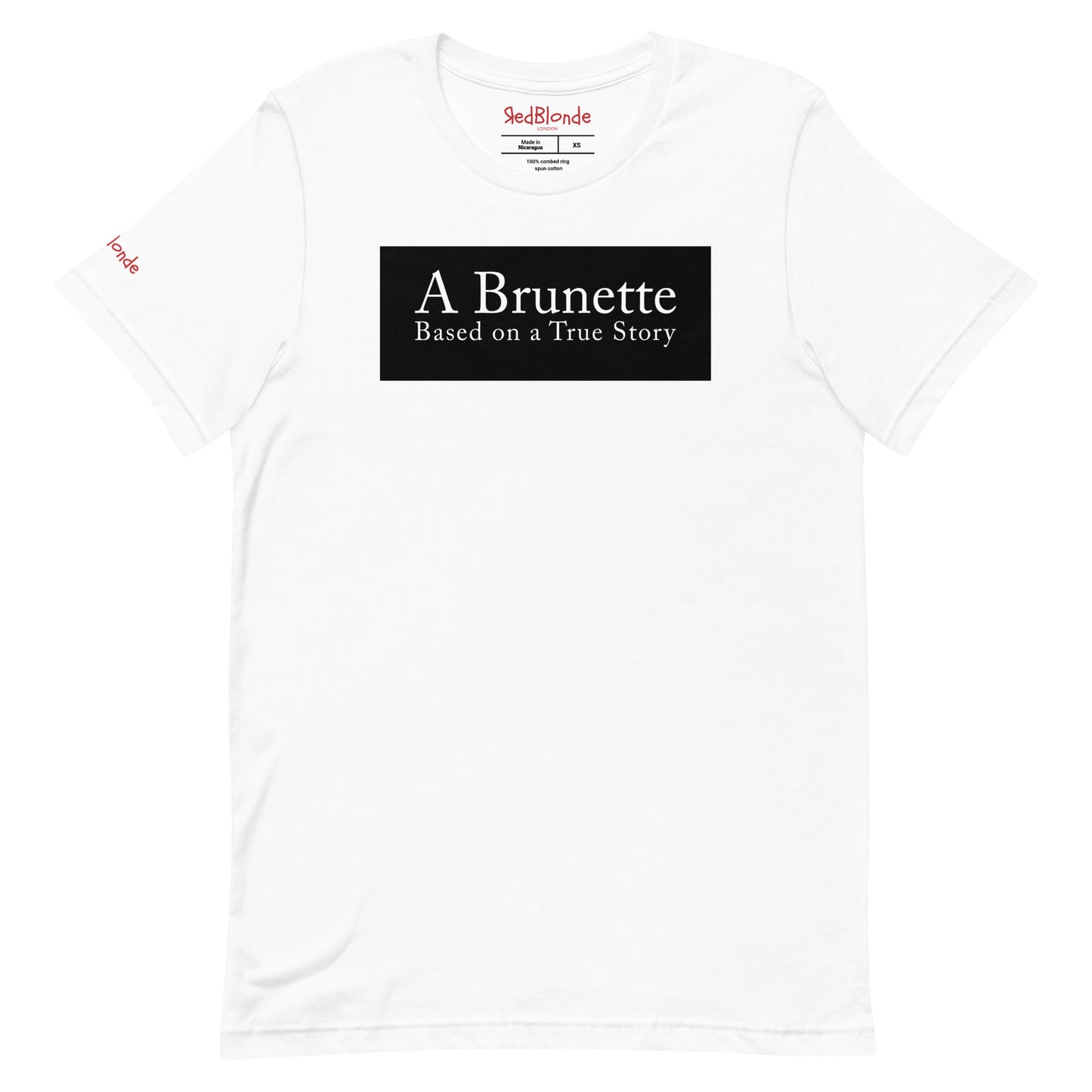 flatlay of a white unisex relaxed fit t-shirt with the slogan 'A Brunette. Based on a True Story' in white adobe caslon font in a black box graphic. Branded RedBlonde London in red on inside neck and right sleeve