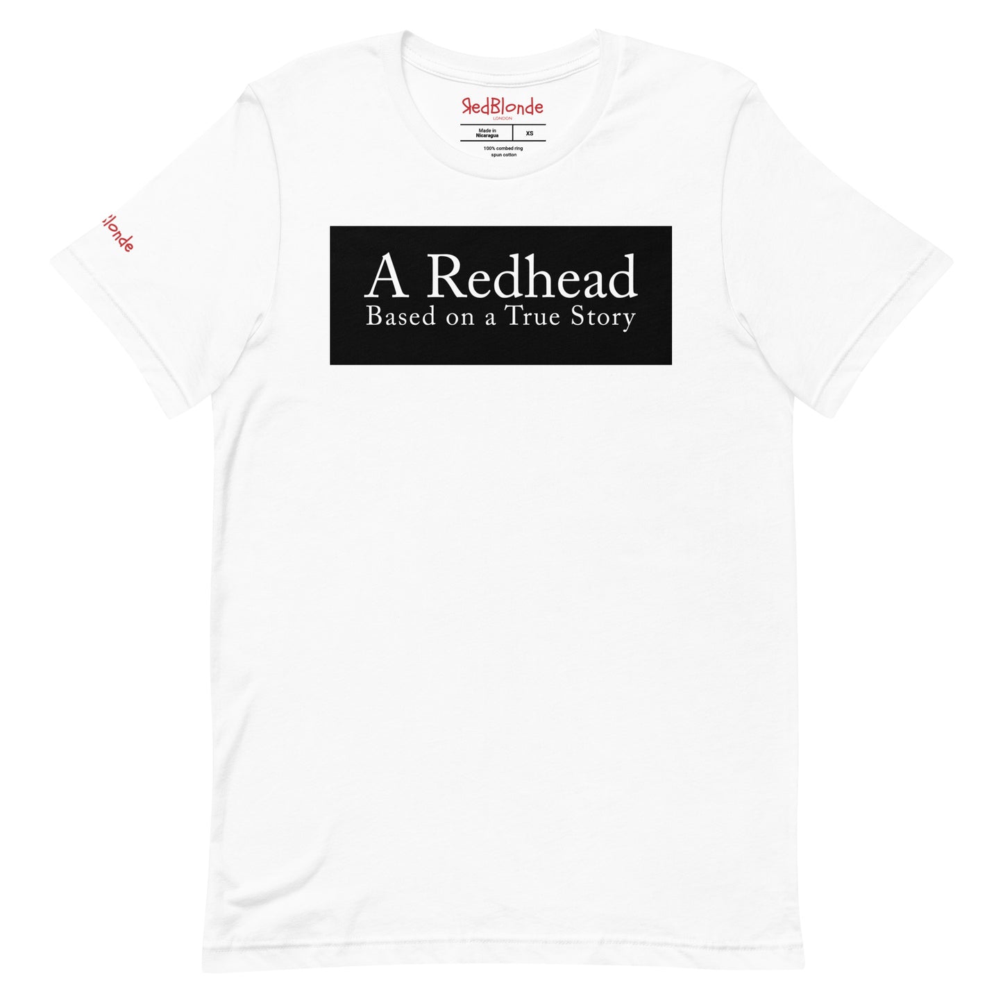 flatlay of a white unisex relaxed fit t-shirt with the slogan 'A Redhead. Based on a True Story' in white text in a black box graphic. Branded RedBlonde in red on inside neck and right shoulder