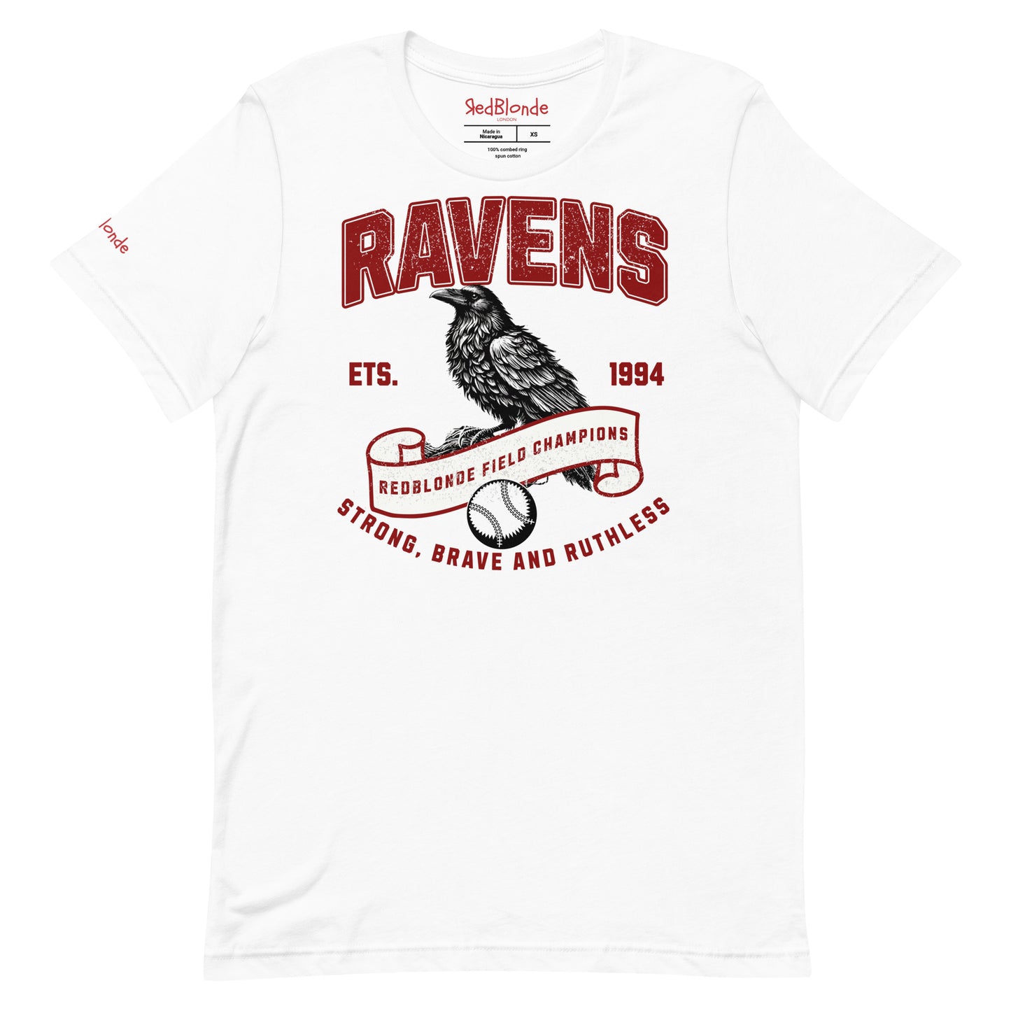 white unisex t-shirt featuring a bold american collegiate vintage-style graphic with the word "RAVENS" in distressed red lettering. Below, a detailed black raven illustration perches on a scroll that reads "REDBLONDE FIELD CHAMPIONS," with a baseball beneath it. Additional text includes "ETS. 1994" and the phrase "STRONG, BRAVE AND RUTHLESS" in red. RedBlonde branding appears on the inner neck label and left sleeve in red text.