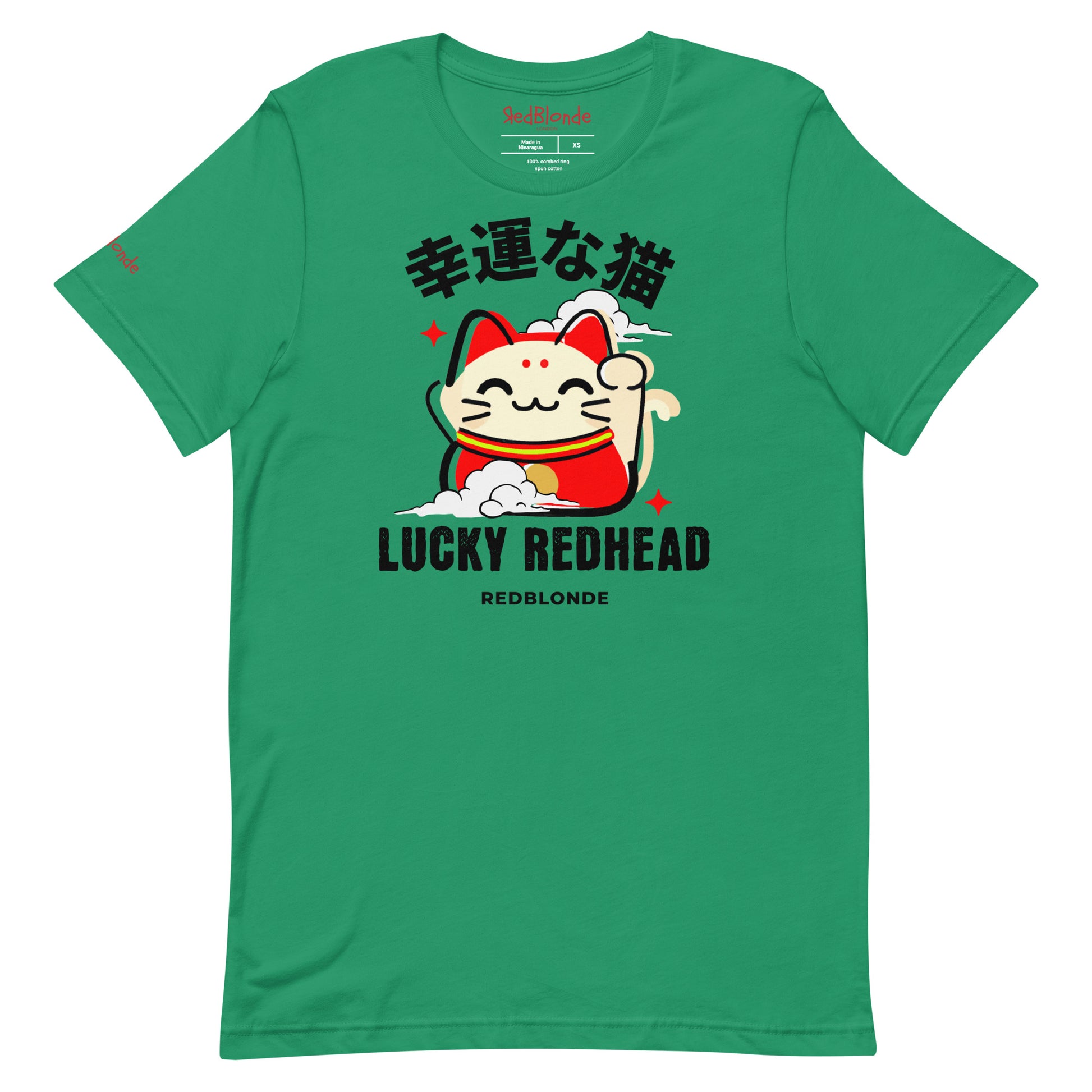 A kelly green unisex T-shirt featuring a colorful maneki-neko (lucky cat) graphic wearing a red outfit with gold accents. Above the cat, Japanese kanji characters are printed in bold white. Below the illustration, the text reads “LUCKY REDHEAD” in distressed white font, with “REDBLONDE” in smaller uppercase letters underneath. The shirt has short sleeves, a classic crew neckline, and a casual, modern fit.