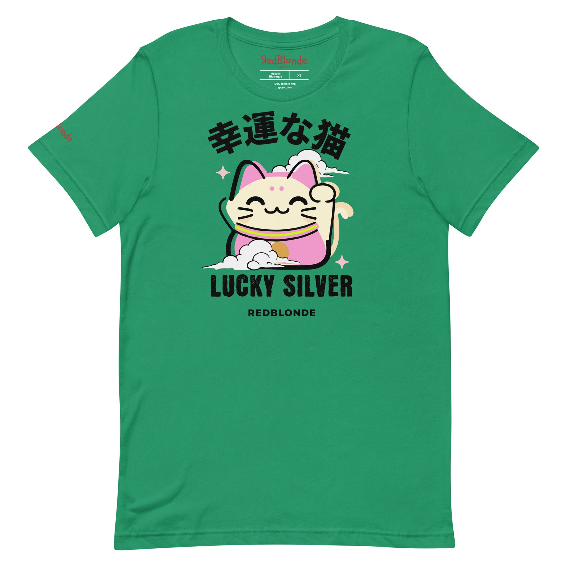 A kelly green unisex T-shirt featuring a colourful illustration of a lucky cat (Maneki-neko) with pink ears and accents, smiling and waving one paw. Above the cat are Japanese characters reading "幸運な猫" (Lucky Cat), and below it are the words "LUCKY SILVER" in bold black font, followed by "REDBLONDE" in smaller text. The design is playful and cute, with stars and a cloud adding charm. The RedBlonde brand name appears in red on the inside label and on the right sleeve.