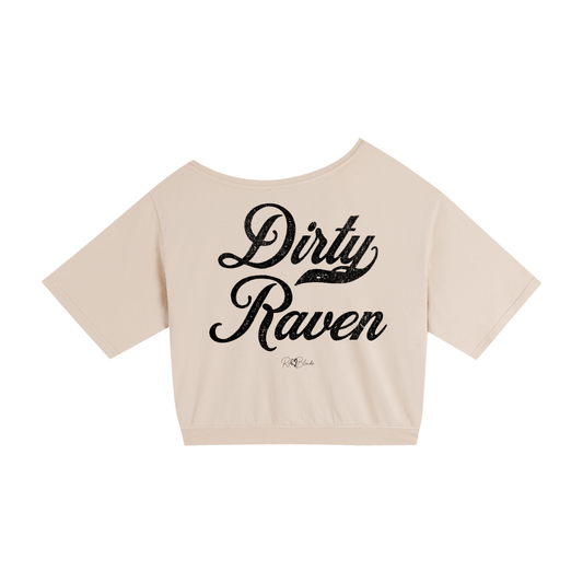 Back view of a Apricot asymmetric off-the-shoulder waist length t-shirt featuring the bold black distressed Milkstore font “Dirty Raven” with the RedBlonde logo printed below. The relaxed, oversized fit and one-shoulder neckline give it a modern, effortless look.