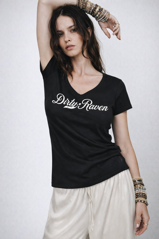 Model wears a fitted black V-neck T-shirt laid flat on a white background. It has short sleeves and a white Milkstore 01 script graphic across the chest reading “Dirty-Raven.” A small RedBlonde label is visible at the inside back neck.