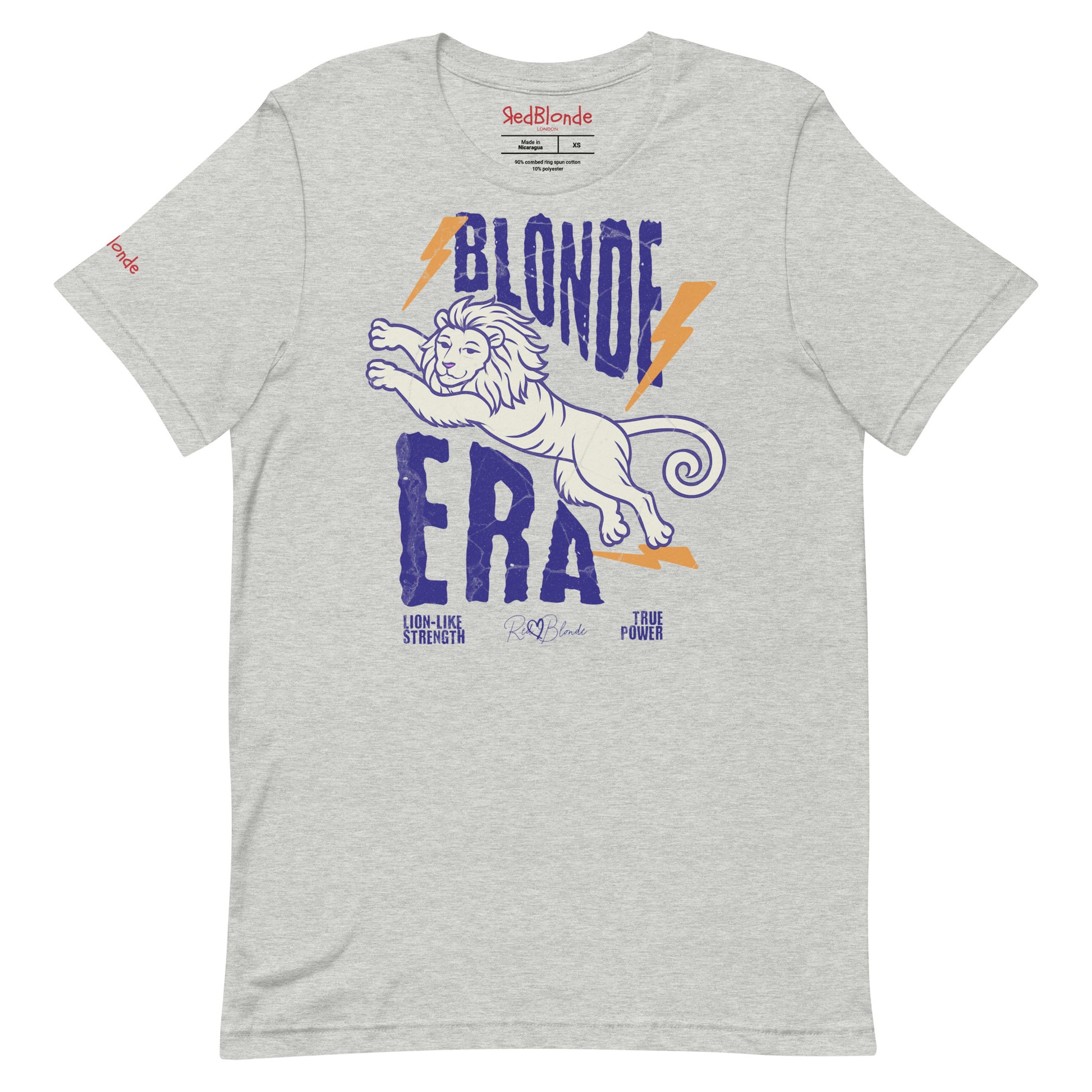 Grey unisex short-sleeve t-shirt featuring a bold graphic of a leaping lion outlined in purple, surrounded by orange lightning bolts. The text “BLONDE ERA” appears in large distressed purple letters, with smaller text reading “LION-LIKE STRENGTH” and “TRUE POWER” underneath. Signed RedBlonde. The brand name “RedBlonde” is printed in red on the inside collar label and on the right sleeve near the cuff.