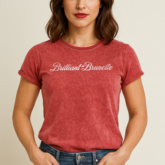 Brunette wears a  unisex relaxed fit vintage red garnet denim wash slogan t-shirt with 'Brilliant Brunette' in milkshake script white font. Branded RedBlonde in red on inside neck and right sleeve