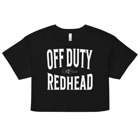 Flatlay of a black women's crop top  graphic t-shirt with “OFF DUTY REDHEAD” in white Helvetica Now font emblazoned on the front, signed off RedBlonde