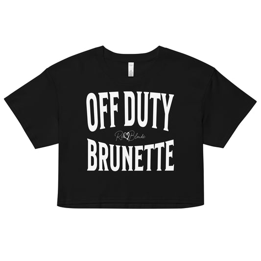 Flatlay of a black women's crop top  graphic t-shirt with “OFF DUTY BRUNETTE” in white Helvetica Now font emblazoned on the front, signed off RedBlonde