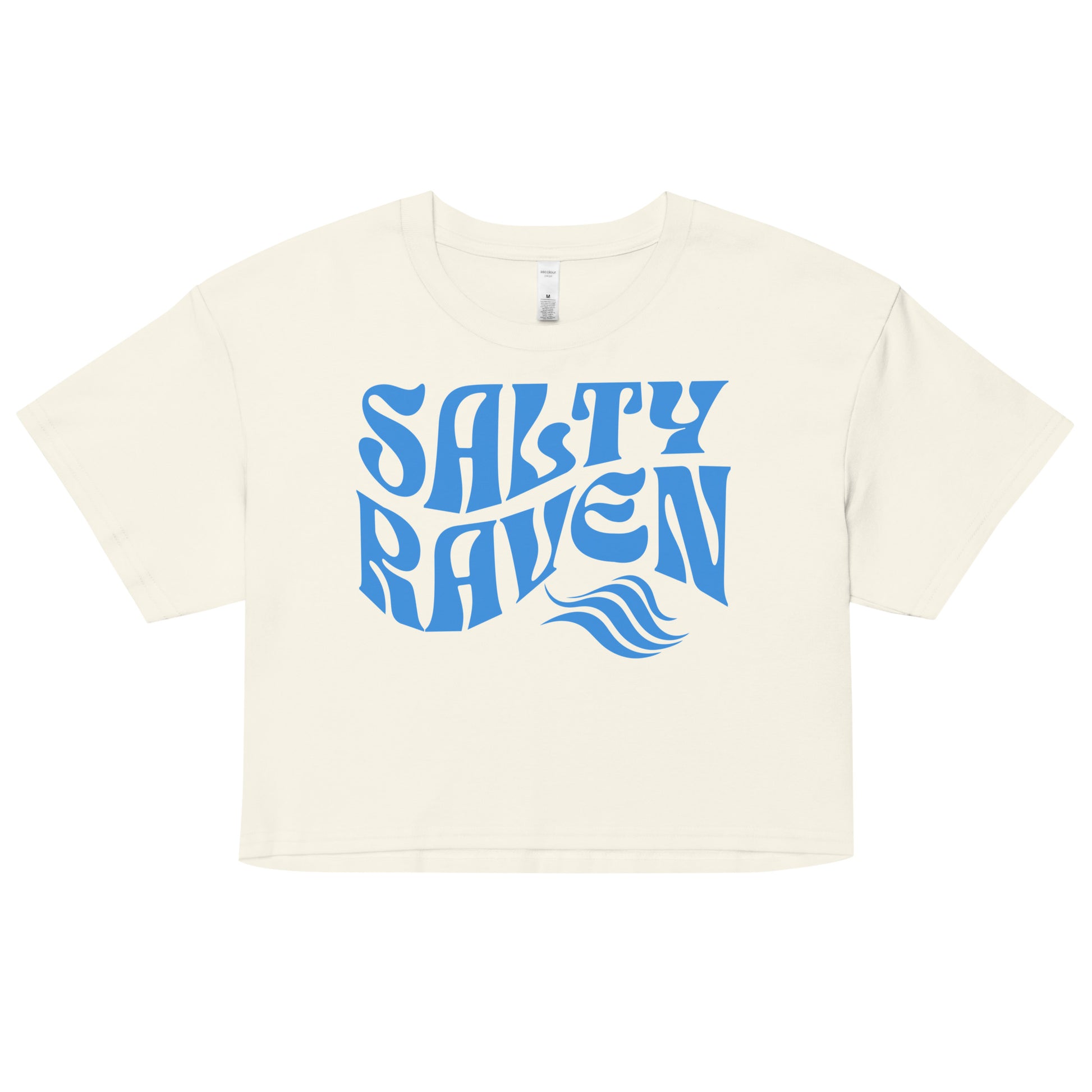 Flatlay of a ecru loose crop top t-shirt with the words ‘Salty Raven’ in blue retro 70s wavy font