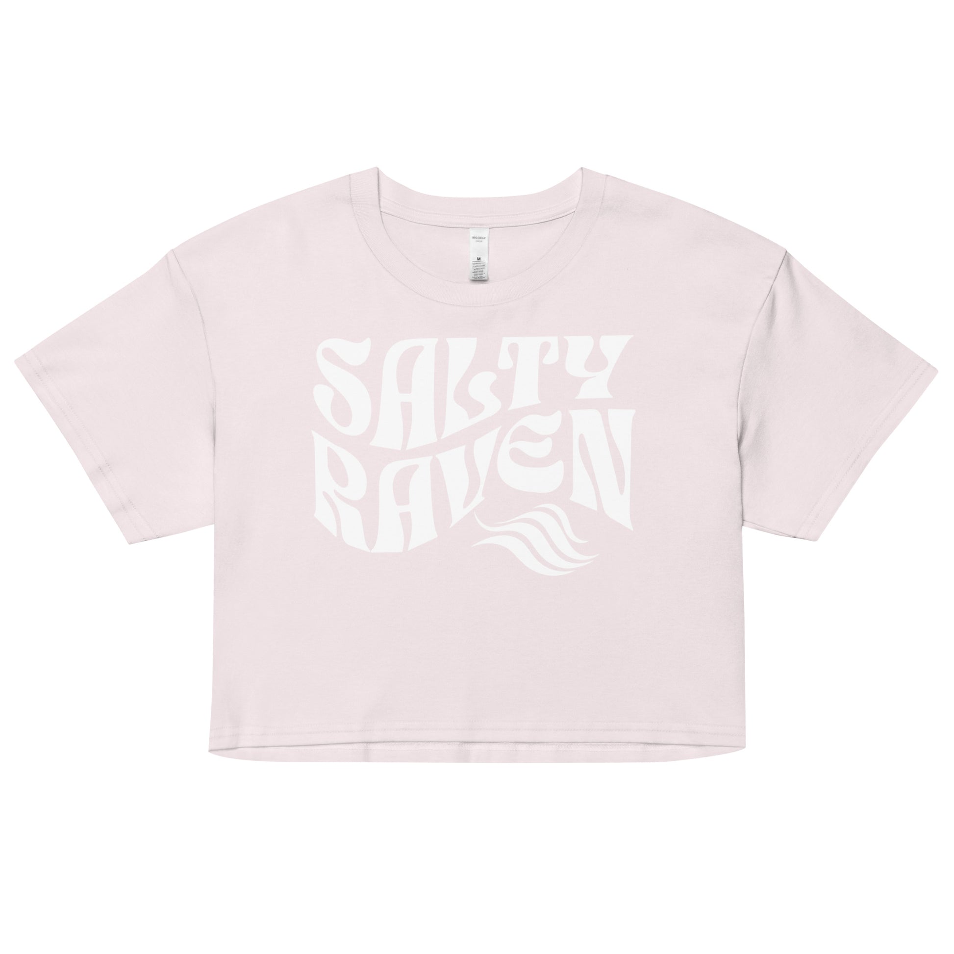 Flatlay of a orchid pale pink loose crop top t-shirt with the words ‘Salty Raven’ in white retro 70s wavy font