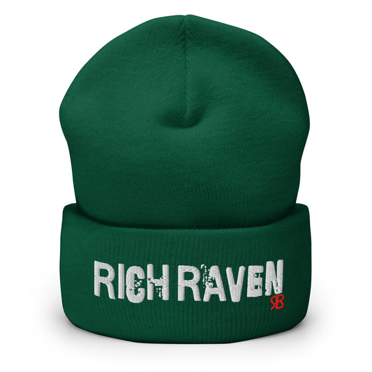 Forest Green Rich Brunette knitted beanie with the embroidered phrase “Rich Raven” in white script and a small red RB logo on the fold-over cuff, displayed against a clean white background.