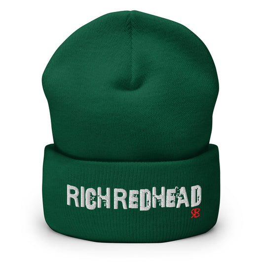 Green cuffed beanie with the embroidered slogan “RICH REDHEAD” in bold white distressed-style lettering, featuring a small red “RB” RedBlonde logo on the right side of the fold. The beanie is shown upright against a clean white background.