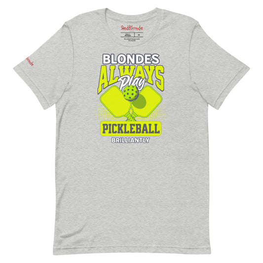 Grey unisex t-shirt featuring the phrase "Blondes Always Play Pickleball Brilliantly" in bold neon yellow and grey lettering, with two neon yellow pickleball paddles and a green pickleball in the center. Branded RedBlonde on inside the neck and on the right sleeve.
