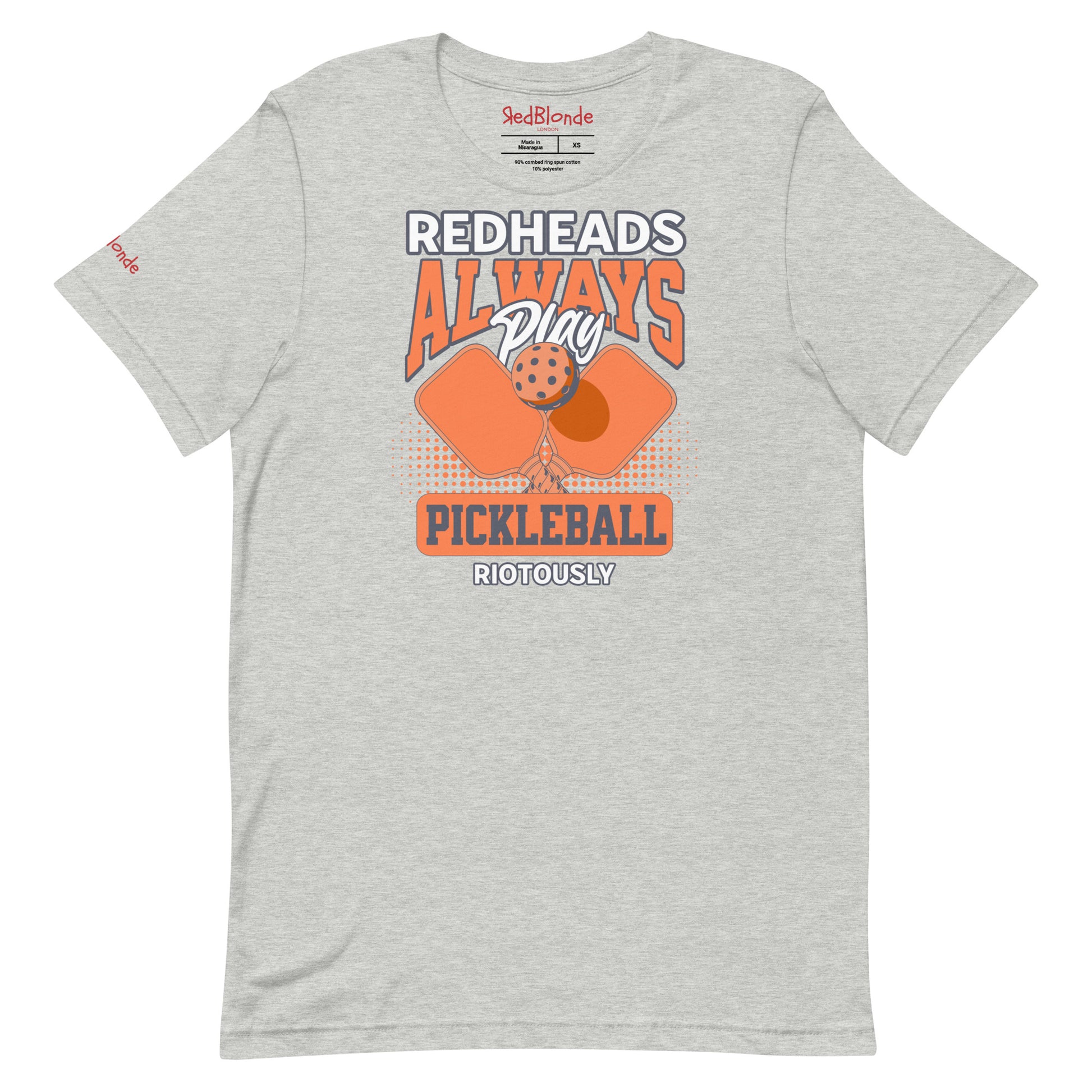 Grey unisex t-shirt with orange graphic that reads "Redheads Always Play Pickleball Riotously," featuring pickleball paddles and ball. Branded RedBlonde on inside neck and right sleeve
