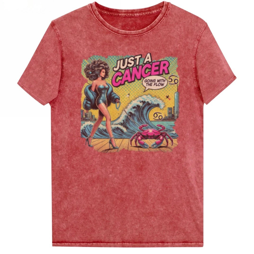 Flatlay of a unisex garnet red denim wash vintage t-shirt with a retro pop-art Cancer graphic featuring a dark-haired woman, wearing a turquoise short strapless catsuit, fur coat and strappy heels, walking a pink crab on a leash, with a high water wave and city backdrop captioned Just an Caner, Going with the Flow'. Branded RedBlonde on inside neck and right sleeve 
