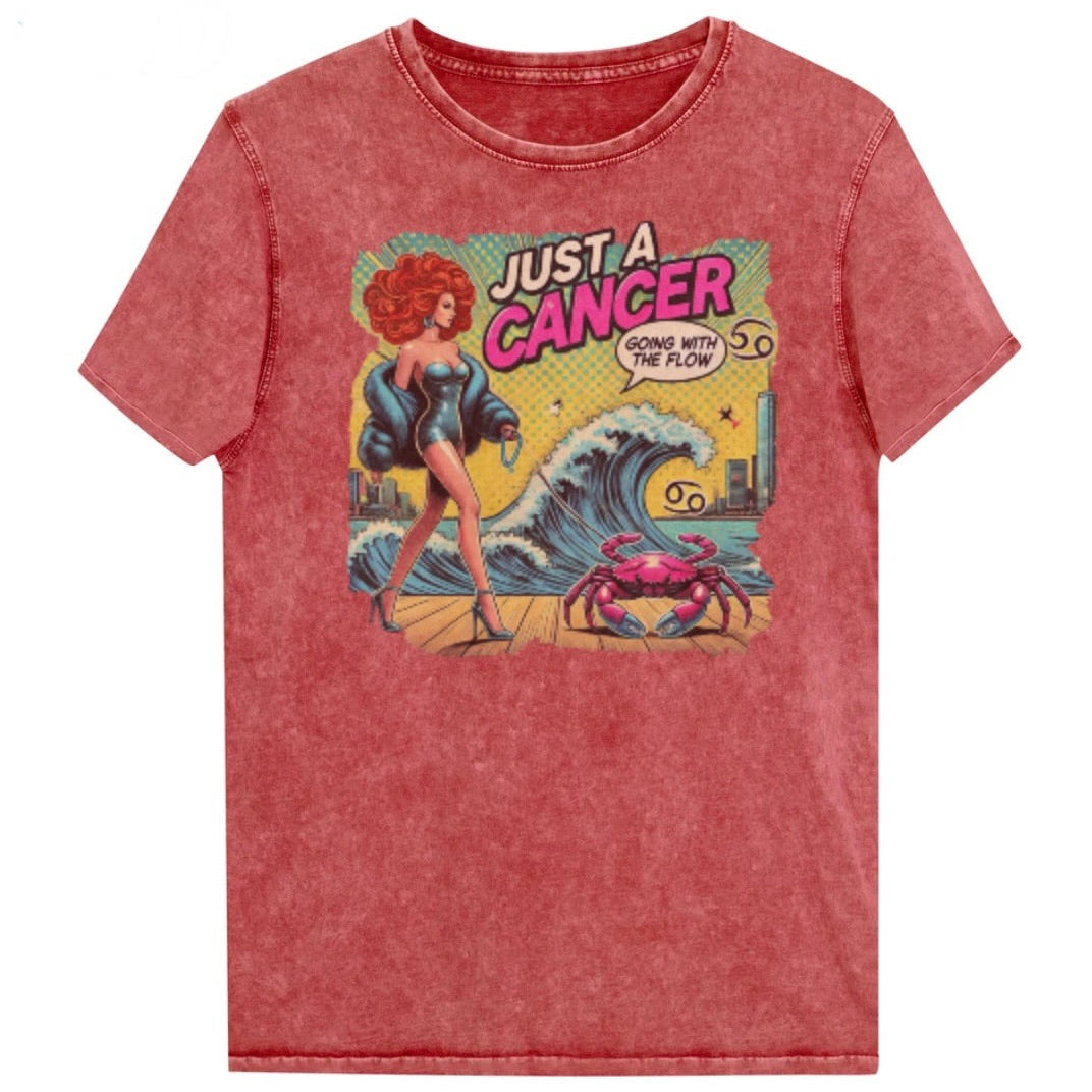 Flatlay of a unisex red garnet denim wash vintage t-shirt with a retro pop-art Cancer graphic featuring a redhead woman, wearing a turquoise short strapless catsuit, fur coat and strappy heels, walking a pink crab on a leash, with a high water wave and city backdrop captioned Just a Cancer, Going with the Flow'. Branded RedBlonde in red on inside neck and right sleeve 