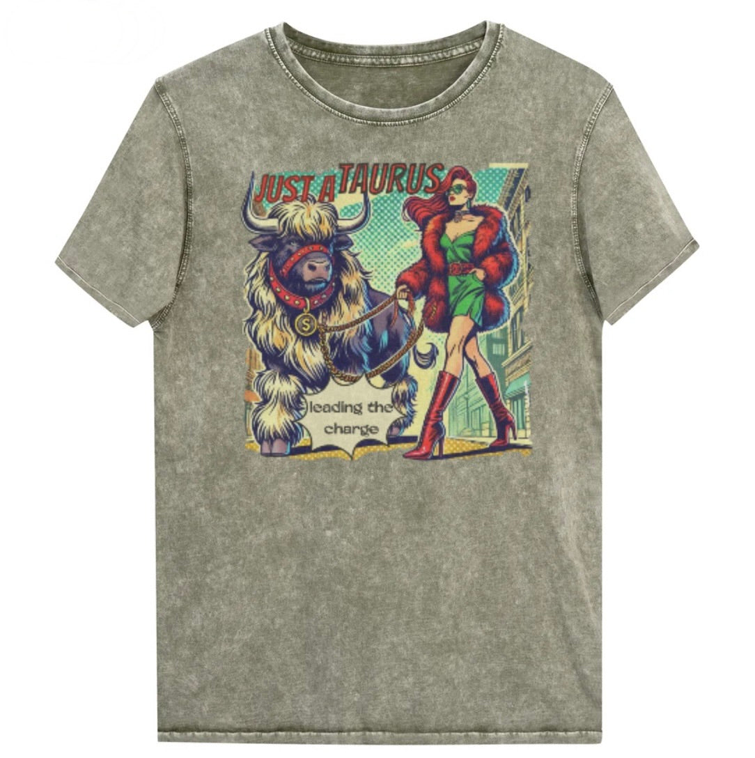 Flatlay of a unisex relaxed fit army green vintage denim wash t-shirt with a retro pop-art taurus graphic featuring a redhead woman with long flowing straight hair, wearing a green dress with a red belt, red high-heeled boots and red fur coat, walking a furry bull with a red collar and medallion in city street captioned ‘Just a taurus leading the charge'. randed RedBlonde on inside neck and right shoulder