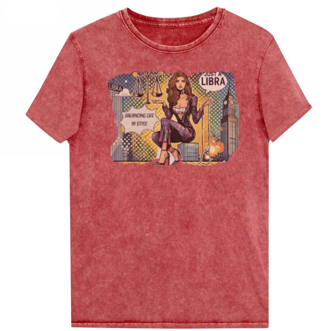 Flatlay of a unisex garnet red denim wash vintage t-shirt with a retro pop-art Brunette Libra graphic featuring a brunette woman, scales, and a city backdrop, captioned ‘Just a Libra, Balancing Life in Style’. Branded RedBlonde on inside neck and right sleeve