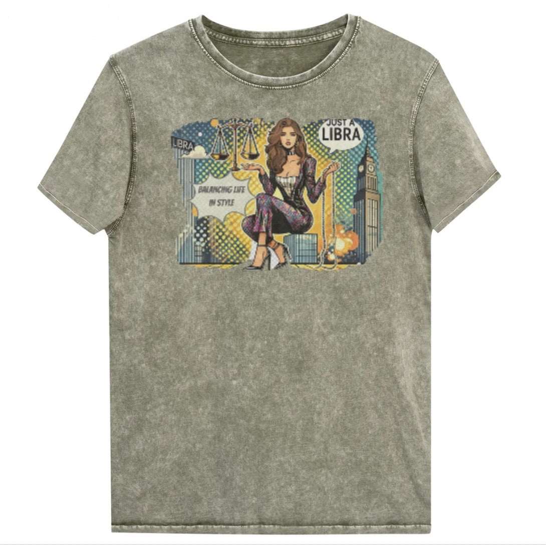 Flatlay of a unisex army green denim wash vintage t-shirt with a retro pop-art Brunette Libra graphic featuring a brunette woman, scales, and a city backdrop, captioned ‘Just a Libra, Balancing Life in Style’. Branded RedBlonde on inside neck and right sleeve
