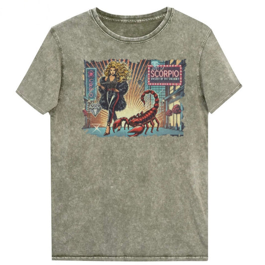 Flatlay of a unisex army green denim wash vintage t-shirt with a retro pop-art Scorpio graphic featuring a blonde woman with long flowing hair, wearing a black pants with a red stripe down the side, a halterneck top and fur coat, next to a large red scorpion walking down the street past a shop window captioned ‘Just an Scorpio, Master of the Smoulder'. Branded RedBlonde in red on inside neck and right shoulder